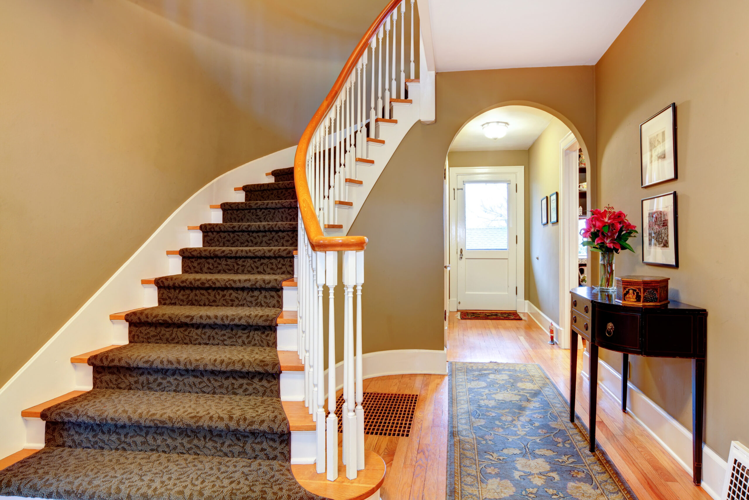 Bright hallway with wood stairs and archway